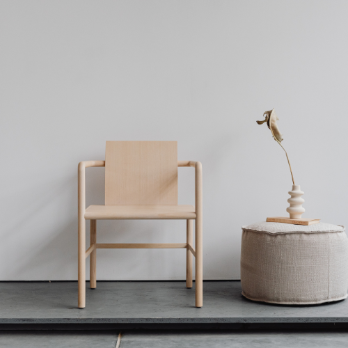 a chair , ottoman and light fitting displayed against a blank wall